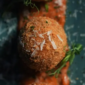 Crisp arancini dusted with parmigiano.