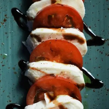 Caprese of buffalo mozzarella and vine tomatoes with balsamic.