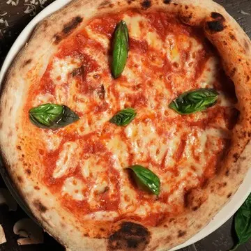 Margherita pizza, basil on melted fior di latte.